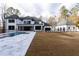 Expansive backyard featuring a modern home design with a swimming pool, patio, and lush lawn at 5211 Powers Ferry Rd, Sandy Springs, GA 30327