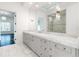 A modern bathroom with a long vanity, marble countertop, custom mirror, and glass-walled shower at 5211 Powers Ferry Rd, Sandy Springs, GA 30327