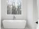 Bright bathroom with a modern soaking tub in front of a window at 5211 Powers Ferry Rd, Sandy Springs, GA 30327