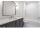 This bathroom offers a large vanity, chrome fixtures, shower-tub combination and white subway tile at 5211 Powers Ferry Rd, Sandy Springs, GA 30327