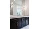 Bathroom vanity featuring black cabinets, marble countertop, and modern lighting at 5211 Powers Ferry Rd, Sandy Springs, GA 30327