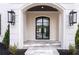 Grand front entrance features a dark metal and glass door, elegant stone floors, and decorative sconces at 5211 Powers Ferry Rd, Sandy Springs, GA 30327
