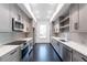 Galley kitchen features gray cabinets, stainless steel appliances, quartz countertops, and a window view at 5211 Powers Ferry Rd, Sandy Springs, GA 30327