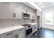 Modern kitchen features sleek gray cabinets, stainless steel appliances, and quartz countertops at 5211 Powers Ferry Rd, Sandy Springs, GA 30327