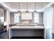 A contemporary kitchen features dual islands with waterfall countertops and pendant lighting at 5211 Powers Ferry Rd, Sandy Springs, GA 30327
