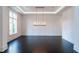 Elegant living room with dark hardwood floors, recessed lighting, and modern chandelier at 5211 Powers Ferry Rd, Sandy Springs, GA 30327