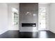 Bright living room showcasing a sleek, modern fireplace with stone surround and dark hardwood flooring at 5211 Powers Ferry Rd, Sandy Springs, GA 30327
