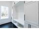 Well-organized mudroom features white built-in cabinets and a bench with natural light from a window at 5211 Powers Ferry Rd, Sandy Springs, GA 30327