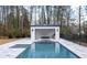 Beautiful pool with an outdoor kitchen featuring a built-in grill and bar at 5211 Powers Ferry Rd, Sandy Springs, GA 30327