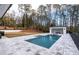 Backyard oasis featuring a luxurious pool, spa, and outdoor kitchen/bar area at 5211 Powers Ferry Rd, Sandy Springs, GA 30327