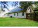 This well kept backyard features a wooden fence, grass and mature trees at 85 Chestnut Dr, Covington, GA 30016