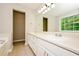 Bright bathroom featuring a double vanity, white cabinetry, and a large mirror reflecting natural light at 85 Chestnut Dr, Covington, GA 30016