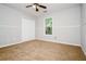 This bedroom has carpeted floors, a ceiling fan and a window at 85 Chestnut Dr, Covington, GA 30016