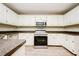 Spacious kitchen with white cabinets, stainless steel appliances, and sleek laminate countertops at 85 Chestnut Dr, Covington, GA 30016