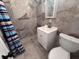 Well-lit bathroom featuring tile walls, shower with curtain, modern sink, and toilet at 2000 Brickton Sta, Buford, GA 30518