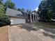 Two-story brick home with white columns, inviting entrance, lush greenery, and large driveway at 2000 Brickton Sta, Buford, GA 30518