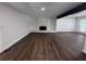 Spacious living room with hardwood floors, fireplace, and large windows offering natural light and serene views at 2000 Brickton Sta, Buford, GA 30518
