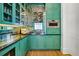 Stylish bar area featuring turquoise cabinets, mirrored backsplash, and a built-in microwave at 3379 Rennes Ne Dr, Brookhaven, GA 30319