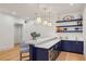 Stylish bar area with navy cabinets, marble countertop, and floating shelves at 3379 Rennes Ne Dr, Brookhaven, GA 30319