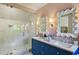 Well-lit bathroom with pink wallpaper, stylish blue vanity and a modern shower at 3379 Rennes Ne Dr, Brookhaven, GA 30319