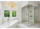 Elegant bathroom featuring a modern soaking tub, frameless glass shower, and crystal chandelier at 3379 Rennes Ne Dr, Brookhaven, GA 30319