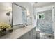 Bright bathroom with marble countertop vanity, decorative mirror, and glass shower at 3379 Rennes Ne Dr, Brookhaven, GA 30319