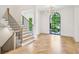 Elegant foyer with herringbone wood floors, staircase, and a window letting in natural light at 3379 Rennes Ne Dr, Brookhaven, GA 30319