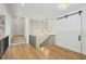Upstairs hallway featuring hardwood floors, sliding barn door, and elegant chandelier at 3379 Rennes Ne Dr, Brookhaven, GA 30319