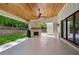 Inviting outdoor patio featuring a stone fireplace, wood ceiling, and seamless access to the backyard at 3379 Rennes Ne Dr, Brookhaven, GA 30319