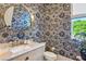Stylish powder room with patterned wallpaper, round mirror, and marble countertop at 3379 Rennes Ne Dr, Brookhaven, GA 30319