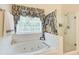 Bathroom featuring a tub, shower, and a large decorative window at 452 Emerald Trce, Jonesboro, GA 30236