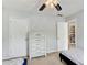 Neutral-toned bedroom features a ceiling fan, two beds, and a white dresser at 452 Emerald Trce, Jonesboro, GA 30236