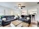Open-concept living room with large windows, comfortable seating, and kitchen view at 452 Emerald Trce, Jonesboro, GA 30236