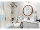 Bathroom featuring a shower-tub combo, round mirror, and white fixtures at 4150 E Chapel Hill Rd, Douglasville, GA 30135