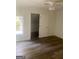 Bright bedroom featuring wood-look flooring, a window, ceiling fan, and access to a closet area at 103 Tiburon Ct, Stonecrest, GA 30038