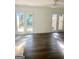 Open living room with wood-look flooring and double doors leading to the outdoor space at 103 Tiburon Ct, Stonecrest, GA 30038