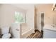 Bathroom with separate tub and shower with a window view and wood-look floors at 1070 Evergreen Oak Way, Dacula, GA 30019
