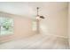 Empty bedroom featuring neutral carpet, ceiling fan, and two large windows at 1070 Evergreen Oak Way, Dacula, GA 30019