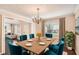 Dining room with chandelier, wood table, blue chairs, and view to living room at 1070 Evergreen Oak Way, Dacula, GA 30019
