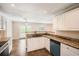 Bright kitchen featuring granite counters, white cabinetry, and stainless steel sink at 1070 Evergreen Oak Way, Dacula, GA 30019