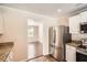 Kitchen area with stainless steel refrigerator and view into adjacent room at 1070 Evergreen Oak Way, Dacula, GA 30019