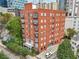 Exterior view of a red brick apartment building surrounded by mature trees at 206 Ne 11Th Ne St # 703A, Atlanta, GA 30309