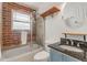 Updated bathroom features brick accent wall, sleek vanity, and shower with glass door at 36 Daniel Se St # 5, Atlanta, GA 30312