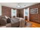Bedroom features exposed brick wall with stylish neutral colored bedding and vintage rug on hardwood floors at 36 Daniel Se St # 5, Atlanta, GA 30312