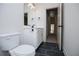 Well-lit powder room boasts a modern vanity and fixtures, complemented by dark floor tiles and a view of the hallway at 8088 Lakeview Pkwy, Villa Rica, GA 30180