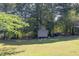 Backyard shed and equipment storage, providing practical outdoor solutions and plenty of trees at 1490 Twin Manor Dr, Loganville, GA 30052