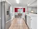 Spacious kitchen featuring stainless steel fridge, white cabinets, and a view to the dining area at 1490 Twin Manor Dr, Loganville, GA 30052