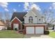 Charming two-story home with a brick and gray exterior, well-manicured lawn, and a two-car garage at 2058 Drogheda Ln, Marietta, GA 30066