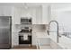 Modern kitchen featuring stainless steel appliances, white countertops, and bright white cabinetry at 2058 Drogheda Ln, Marietta, GA 30066