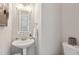 Stylish powder room featuring a pedestal sink, decorative mirror, and modern fixtures at 2058 Drogheda Ln, Marietta, GA 30066